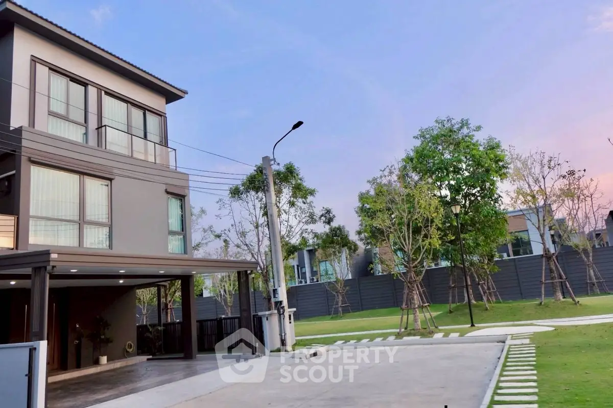 Modern three-story house with spacious driveway and lush garden