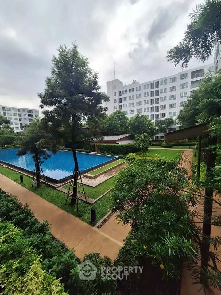 Luxurious residential complex with pristine pool and lush gardens, offering serene living environment.