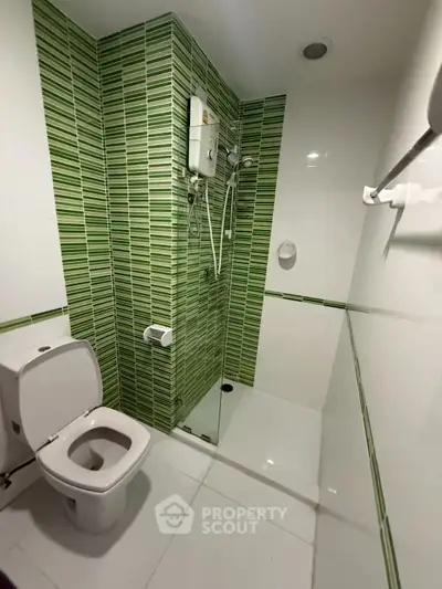 Modern bathroom with green tile accents and sleek fixtures