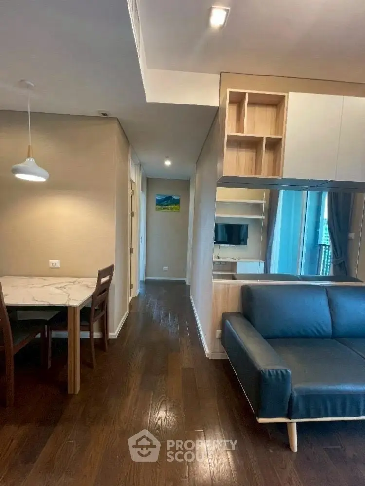 Modern living room with sleek furniture and wooden flooring in a stylish apartment.