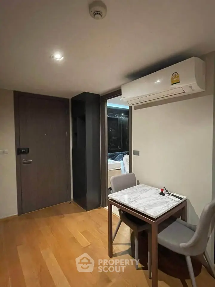 Cozy dining area with wooden flooring and modern air conditioning unit in a stylish apartment.