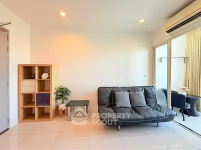 Modern living room with sleek sofa and balcony access in a bright apartment.
