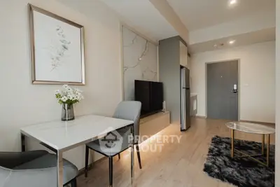 Modern living room with stylish decor and open layout, featuring a sleek TV setup and elegant dining area.