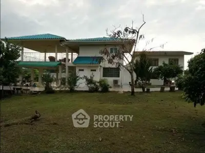 Charming countryside house with spacious garden and unique blue roof, perfect for serene living.