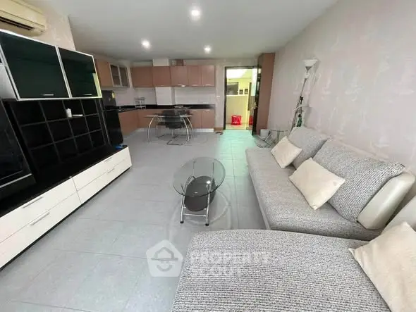 Spacious modern living room with stylish furniture and open kitchen layout.