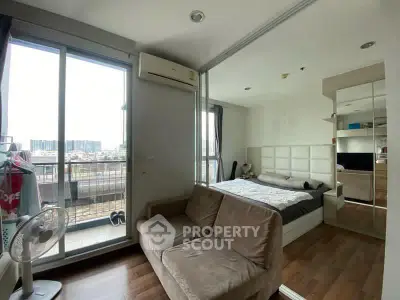 Modern studio apartment with balcony and city view, featuring cozy living area and stylish bedroom.
