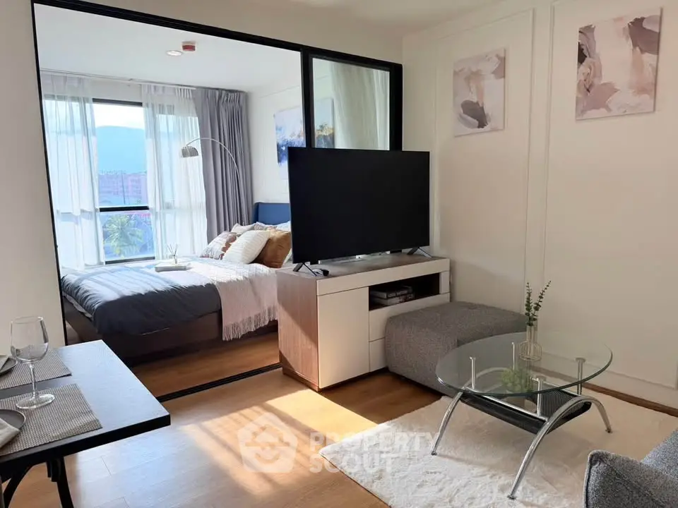 Modern living room with glass partition and cozy bedroom view