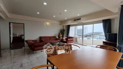 Spacious living room with modern furniture and large windows offering city views.