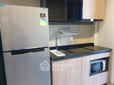 Modern kitchen with sleek appliances and stylish cabinetry in a compact layout.