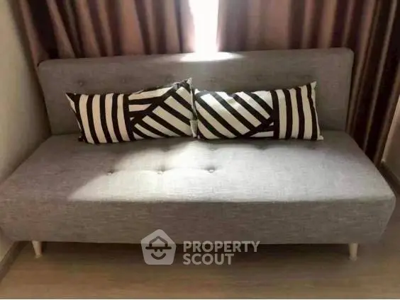 Modern gray sofa with stylish striped pillows in a cozy living room setting.