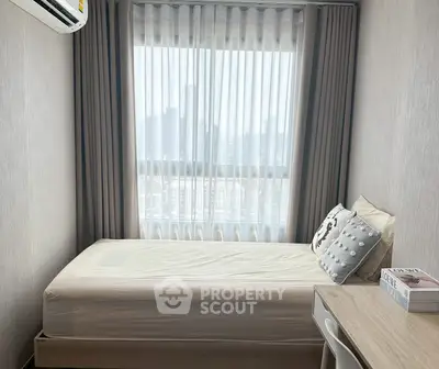 Cozy bedroom with city view, featuring a single bed and study desk, perfect for urban living.