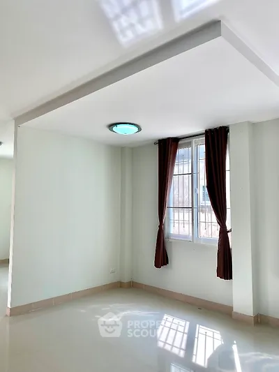 Spacious unfurnished room with large window and modern lighting