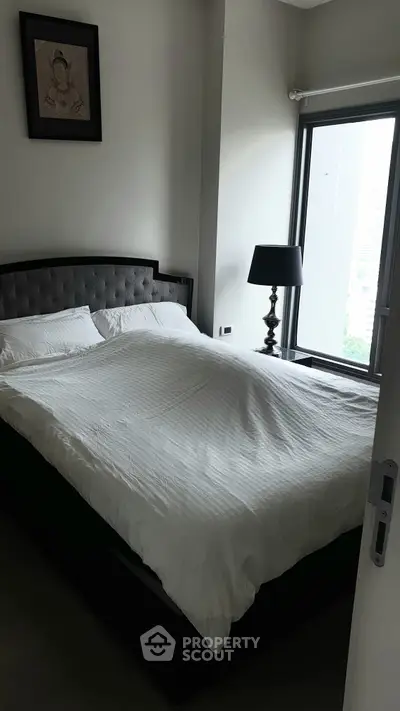 Cozy bedroom with large window and elegant decor in modern apartment