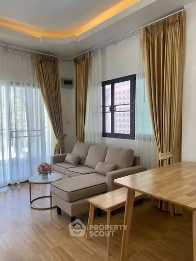 Chic living room with cozy beige sofa, elegant curtains, and natural light.