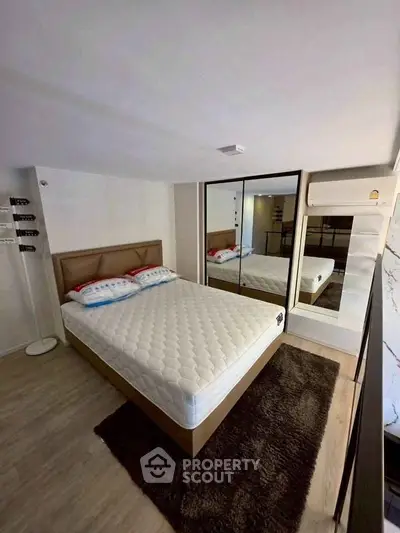 Modern bedroom with mirrored wardrobe and cozy decor in stylish apartment.