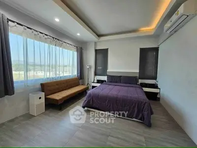 Spacious modern bedroom with large windows and stylish decor