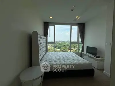 Spacious bedroom with large window offering scenic views and modern furnishings.