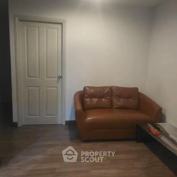 Cozy living room with brown leather sofa and wooden flooring