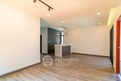 Spacious open-plan living area with modern flooring and stylish lighting, perfect for contemporary living.