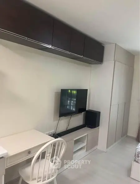 Modern living room with sleek TV setup and stylish furniture in a cozy apartment.