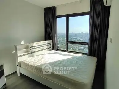 Spacious bedroom with large window offering stunning city views