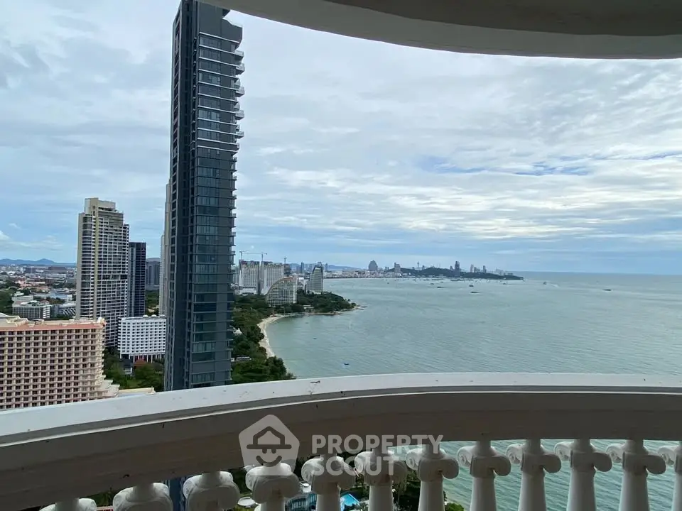 Stunning high-rise balcony view of city skyline and ocean, perfect for luxury living.