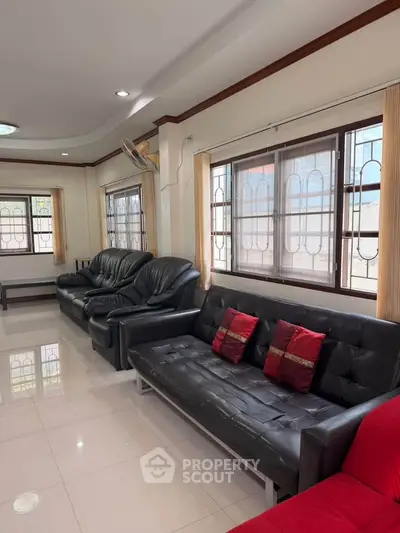 Spacious living room with modern leather sofas and large windows for natural light.