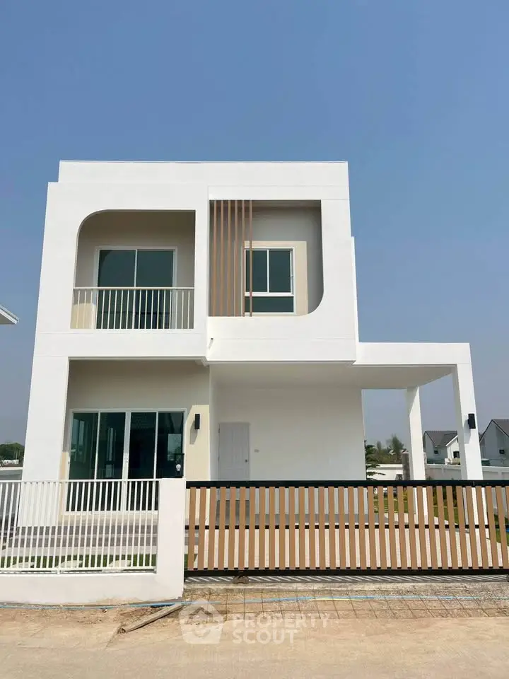 Modern two-story white house with minimalist design and spacious balcony