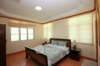 Spacious bedroom with large windows and elegant furnishings