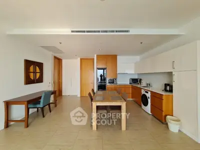 Spacious open-layout kitchen with modern appliances and dining area in a contemporary apartment.
