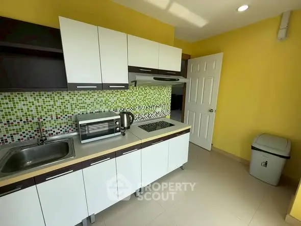 Modern kitchen with vibrant yellow walls and sleek cabinetry