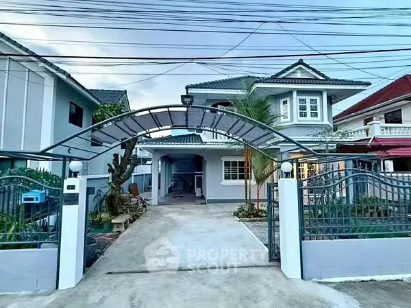 Charming two-story house with gated entrance and spacious driveway in a serene neighborhood.