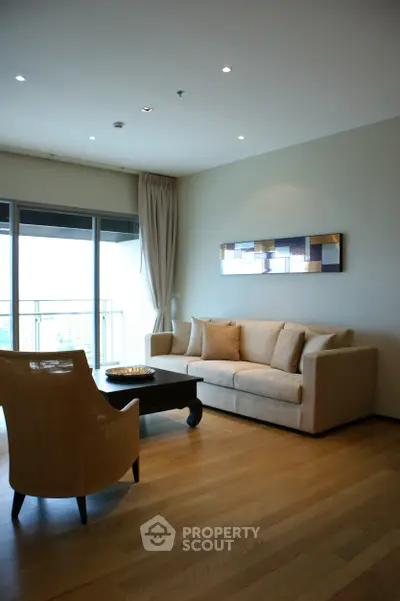 Modern living room with elegant furniture and large balcony view.