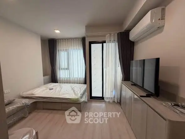 Modern bedroom with large window, air conditioning, and sleek furnishings in a stylish apartment.
