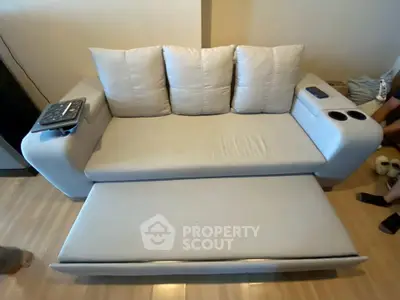 Modern living room with sleek convertible sofa and wooden flooring, perfect for urban apartments.