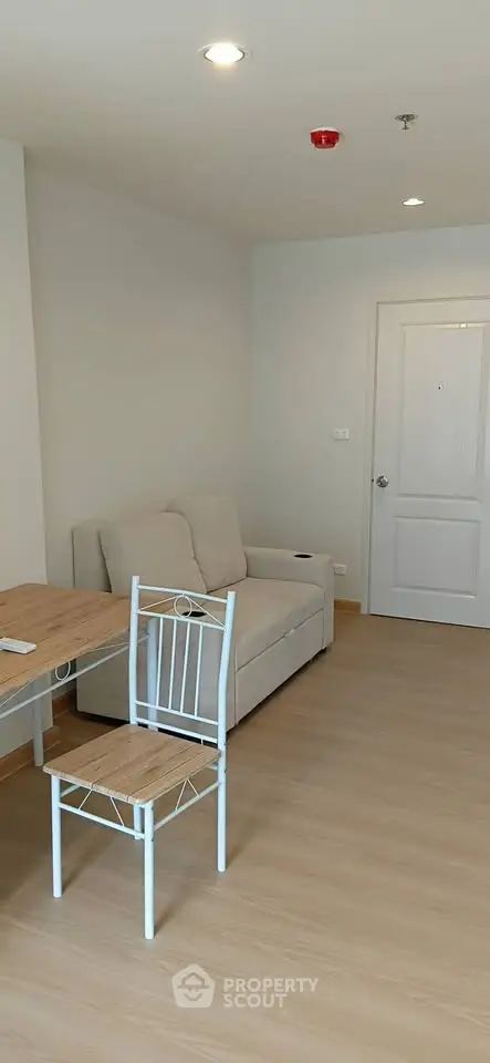 Cozy living room with light wood flooring and modern furniture in a stylish apartment.