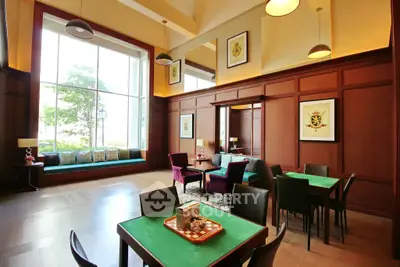 Luxurious living room with high ceilings and elegant decor, featuring large windows and stylish furniture.