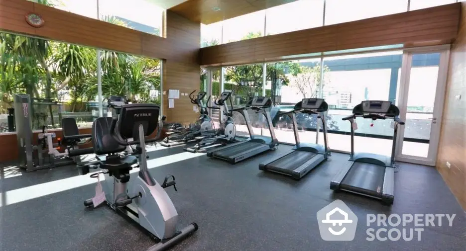 Modern gym with state-of-the-art equipment and large windows offering a refreshing view.