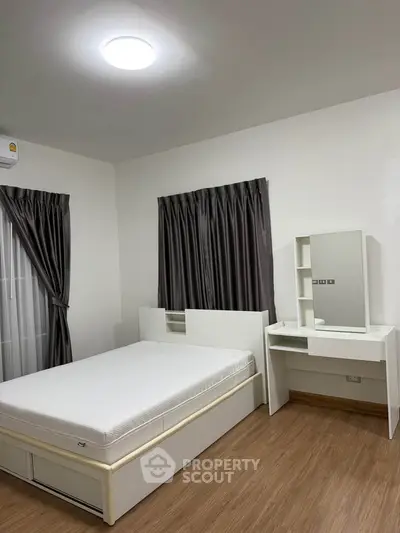 Modern bedroom with sleek furniture and wooden flooring, featuring a comfortable bed and stylish curtains.