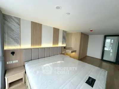 Spacious modern bedroom with elegant decor and ample natural light.