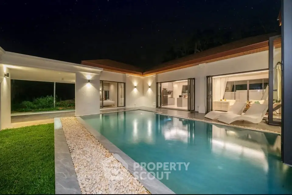 Luxurious modern villa with stunning pool and elegant outdoor lighting at night.