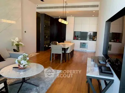 Modern open-plan living room with elegant dining area and stylish kitchen in luxury apartment.