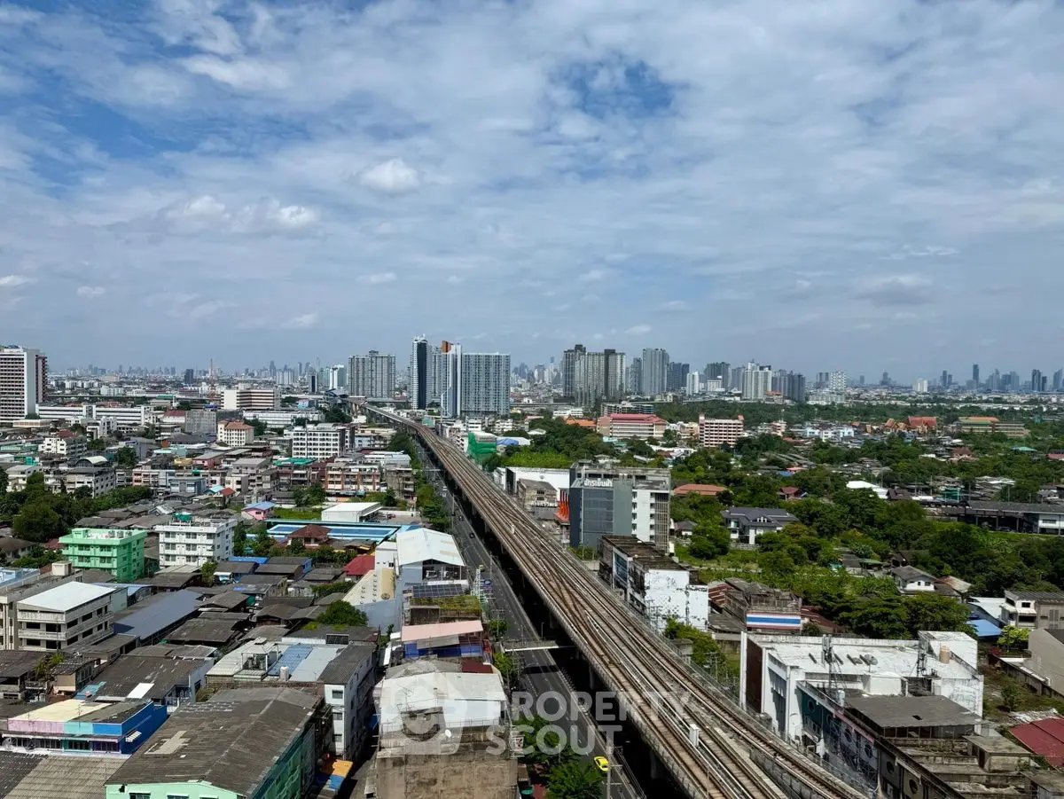 Stunning cityscape view showcasing urban skyline and railway tracks under a clear blue sky.