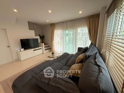 Spacious living room with modern decor and large windows for natural light.