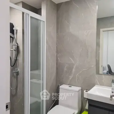 Modern bathroom with sleek shower and elegant fixtures in contemporary apartment.