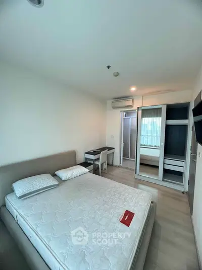 Modern bedroom with sleek furniture and ample natural light, featuring a comfortable bed and stylish wardrobe.