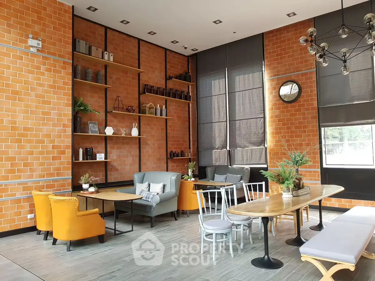 Stylish modern living room with brick walls, cozy seating, and large windows for natural light.