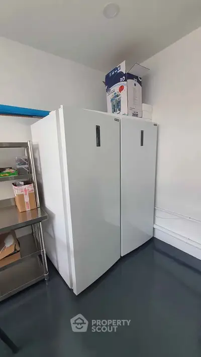 Spacious storage room with modern appliances and shelving unit.
