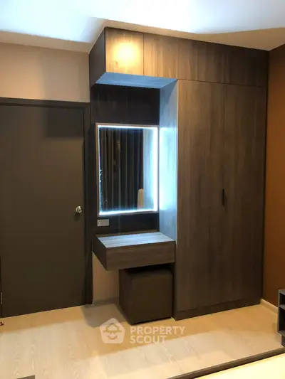 Modern bedroom with sleek wooden wardrobe and illuminated vanity mirror