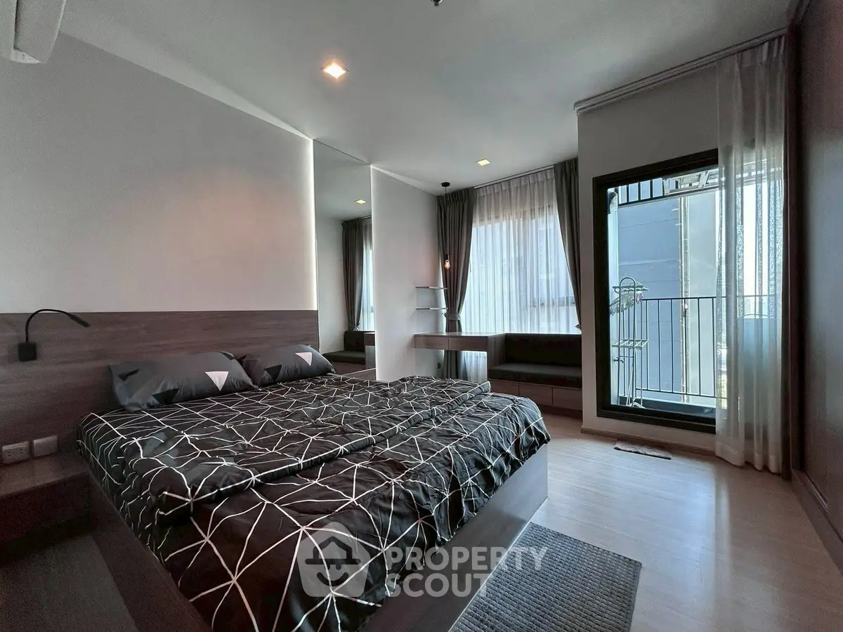 Modern bedroom with stylish decor and balcony access in a luxury apartment.